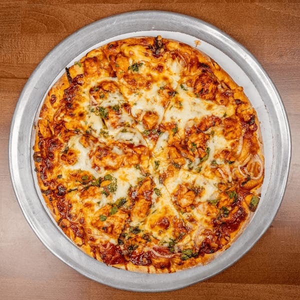 A Chicago's Pizza BBQ chicken pizza, topped with melted cheese, chicken, and cilantro.