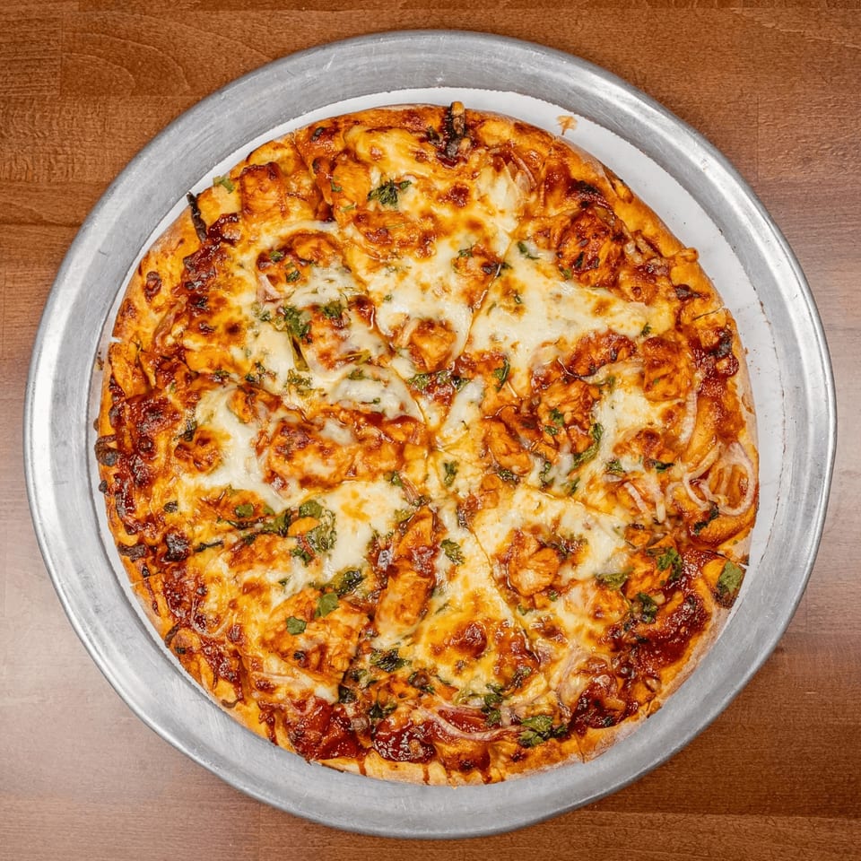 A Chicago's Pizza BBQ chicken pizza, topped with melted cheese, chicken, and cilantro.
