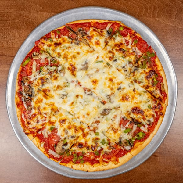 A Chicago's Pizza pie, cut into squares, with melted cheese, mushrooms, and green peppers.